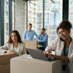 Pleased corporate employee and her coworkers conducting office move